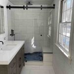 Modern bathroom remodel with rain shower Elegant bathroom design with marble countertops Small bathroom renovation with efficient storage Bathroom renovation with white and gray tiles Renovated rustic bathroom with wood details