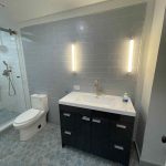 Modern bathroom remodel with rain shower Elegant bathroom design with marble countertops Small bathroom renovation with efficient storage Bathroom renovation with white and gray tiles Renovated rustic bathroom with wood details